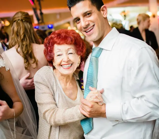 Old woman with red hair and grandson dancing