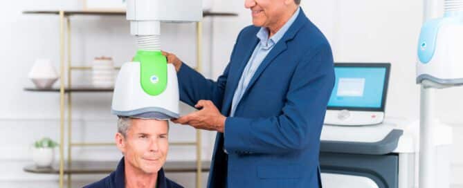 Clinician positioning a BrainsWay TMS device on a patient during a session, demonstrating how TMS treatment for anxiety is administered